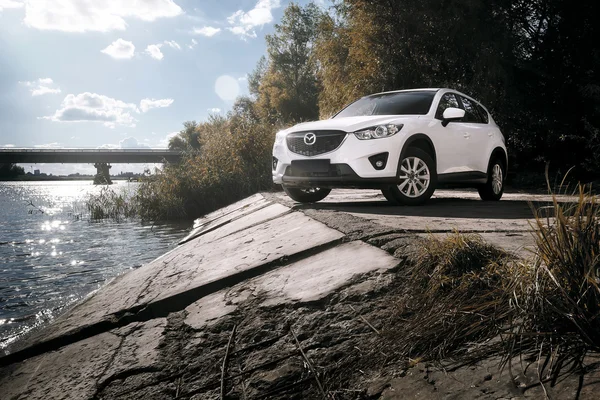 Araba Mazda Cx-5 gündüz nehir yakınındaki asfalt kırsal yol üzerinde durmak