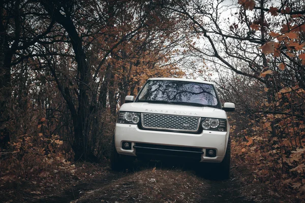 Coche blanco Land Rover Range Rover parada en el lado del condado fuera de la carretera en las nubes dramáticas durante el día — Foto de Stock