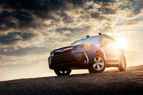 Car Subaru Forester stojí na venkovské silnici při západu slunce — Stock fotografie