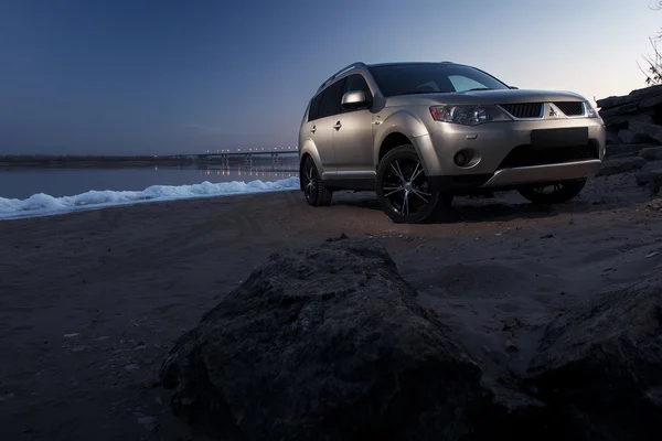 Samochód Mitsubishi Outlander pobyt na wybrzeżu lodu o zachód słońca zima — Zdjęcie stockowe