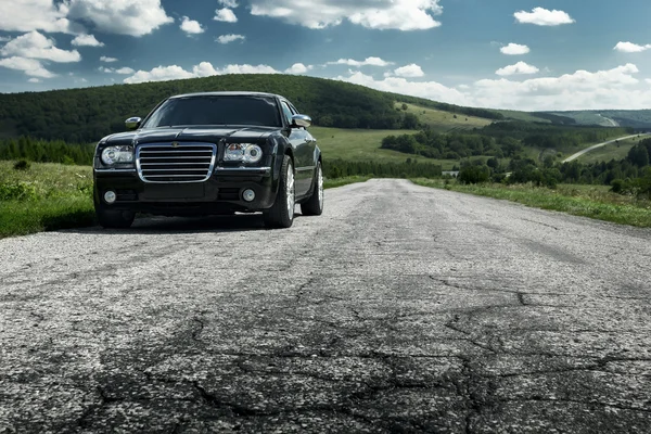 Black car Chrysler 300c stand on the asphalt road at daytime — Stock Photo, Image