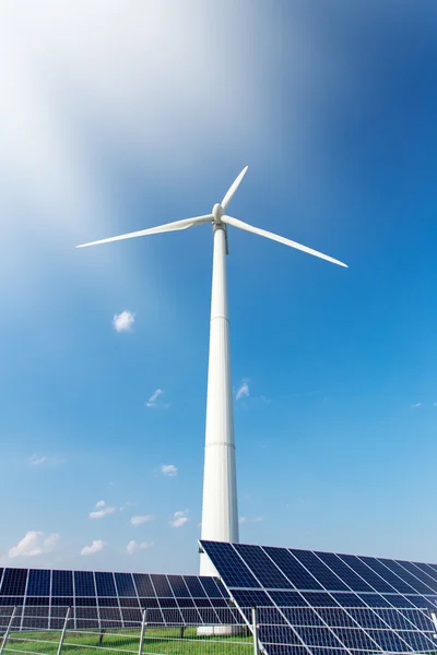 Molino de viento y paneles solares en el cielo azul durante el día — Foto de Stock