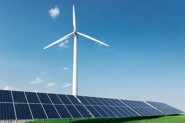 Molino de viento y paneles solares en el cielo azul durante el día — Foto de Stock