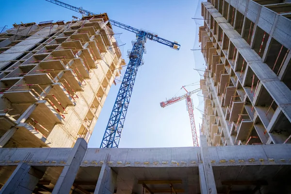 Crane şantiyesi çalışıyor. Beton konutlu gökdelenler şehirdeki binalar