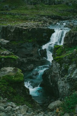 İzlanda 'nın güzel doğa dramatik manzarası. Dağlarda şelale. Soğuk tonlu filtre