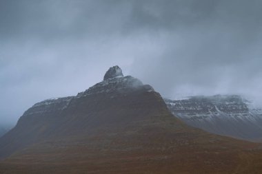 Batı Fjords ya da The Westfjords Kuzey İzlanda 'da bir bölgedir. Dramatik karamsar gökyüzü doğa manzarası. Dağlarda alçak bulutlar