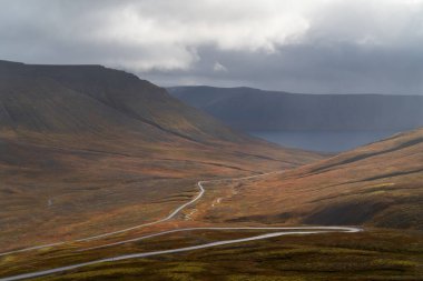 Batı Fiyort 'taki virajlı yol ya da Kuzey İzlanda' daki Westfjords bölgesinde. Dramatik karamsar gökyüzü doğa manzarası