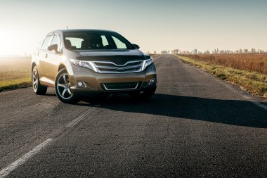 car on the asphalt road at sunset