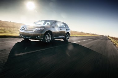 Car drive speed fast on the asphalt road toyota venza at sunset summertime