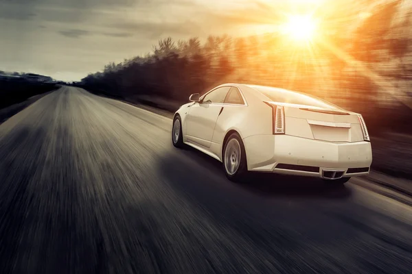 Coche velocidad de conducción rápida en la carretera al atardecer cadillac — Foto de Stock