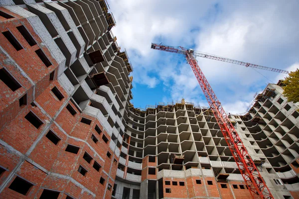 Construcción de grúas ladrillos edificio de hormigón en la ciudad —  Fotos de Stock