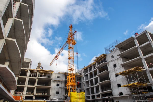 Construcción de grúas ladrillos edificio de hormigón en la ciudad —  Fotos de Stock