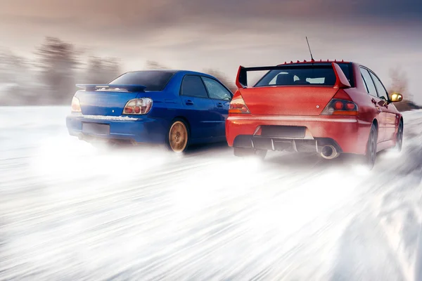 Dvě auta, Subaru Impreza Wrx Sti a Mitsubishi Lancer Evolution soutěžit v závodě v zimě — Stock fotografie