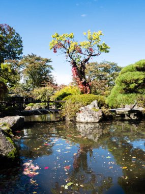 Japonya 'nın Nagano bölgesindeki Suwa' da yeniden inşa edilen Takashima şatosunun yanında göleti olan geleneksel Japon halk bahçesi.