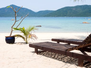 Mavi suyu olan beyaz kumlu bir sahilde güneşli yataklar - Balina Adası, Vietnam