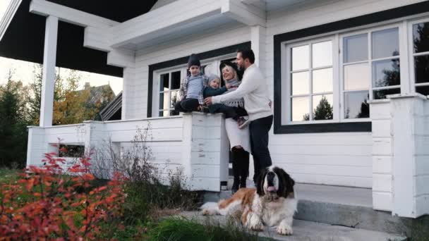 Young happy family with children and big dog having fun near their house — Stock Footage Young happy family with children and big dog having fun near their house Stock Footage