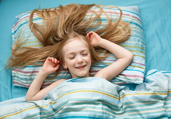 Niña de 5 años con el pelo largo y rubio sonriendo mientras duerme — Foto de Stock