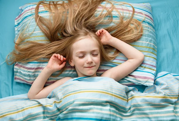 Niña de 5 años con el pelo largo y rubio sonriendo mientras duerme — Foto de Stock