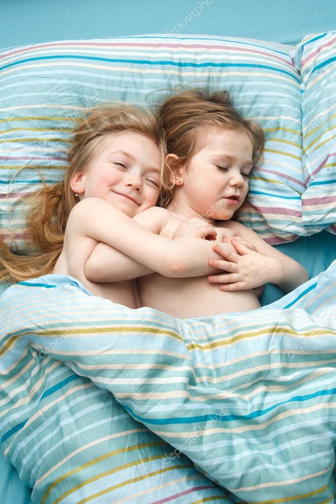 сестры спят в обнимку. две сестры спят. слип сестрички. две сестренки спят. Two kids twin sisters one sleeping on the other.
