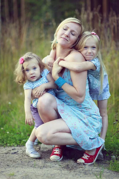 Guapas niñas abrazando mamá — Foto de Stock