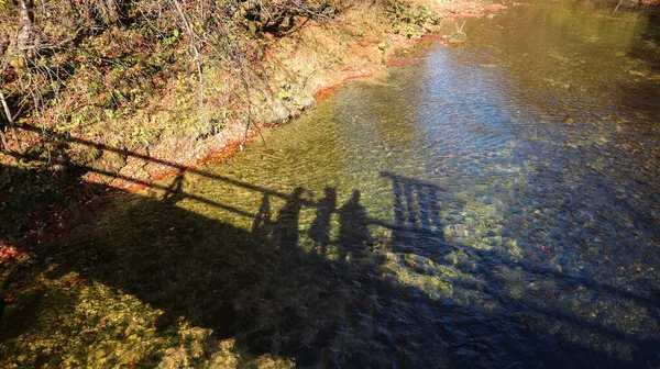 Turyści Filmujący Swój Cień Podczas Przejścia Przez Stary Drewniany Most — Zdjęcie stockowe