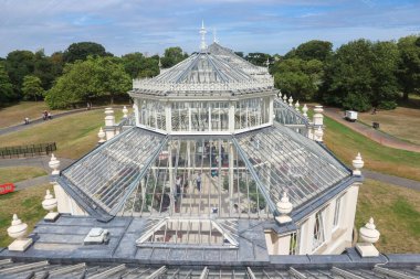 Londra, İngiltere - 11 Ağustos 2018:: Kew Gardens 'ta büyük pencereli ve cam çatılı beyaz seralar güneşin kapalı alandaki tropikal bitkileri aydınlatmasına izin verir
