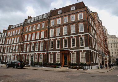 Londra, İngiltere - 12 Ağustos 2018: Yağmurlu gökyüzünün altında kırmızı tuğlalı evler dizili harika Londra sokakları