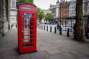 Londra, İngiltere - 12 Ağustos 2018: Londra şehir caddesindeki kaldırımda ünlü kırmızı telefon kulübesi, en çok bilinen İngiliz sembollerinden biri.