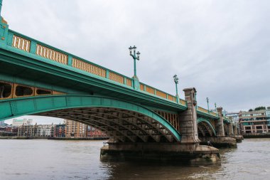 Londra, İngiltere - 12 Ağustos 2018: Birçok Londra şehir köprüsünden biri, Southwark Köprüsü, Thames Nehri 'ni geçiyor, yeşil rengiyle ünlü