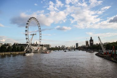 Londra, İngiltere - 13 Ağustos 2018: Londra Gözü, popüler dönme dolap Thames nehri ve limanında güneş batarken demirlemiş gemilerle birlikte