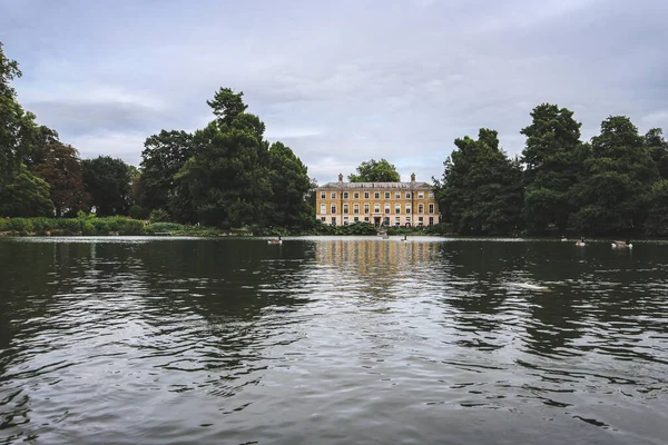 Londra, İngiltere - 11 Ağustos 2018: Kew Gardens, Londra 'da ağaçlarla çevrili sarı göl evi