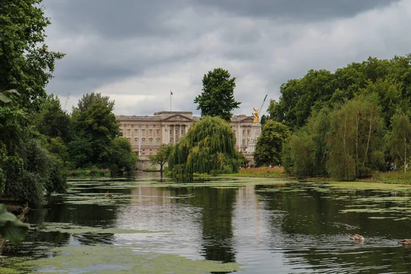 Londra, İngiltere - 12 Ağustos 2018: Güzel, yeşil St. James Park Buckhingham Sarayı 'nın önünde yağmurlu gökyüzünün altında