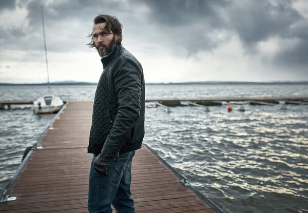 Handsome smart guy resting by the lake