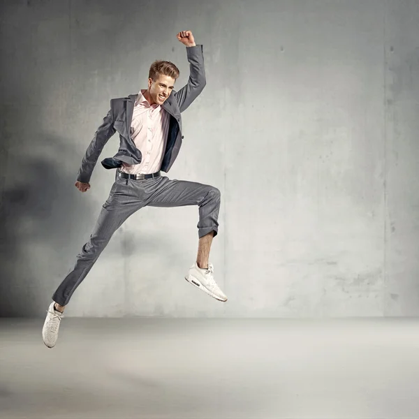 Trendy elegant guy jumping in the air — Stock Photo, Image