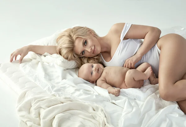 Jonge blonde moeder met een pasgeboren baby — Stockfoto