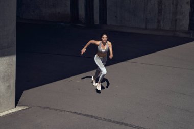 Esmer bir kızın portresi, tünelde koşan genç bir atlet.