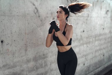 Şehirli boks antrenmanı yapan çekici esmer kadın.