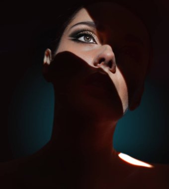 Gölgede saklanan esmer kadının yakın plan portresi