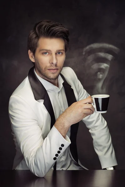 Calm man drinking coffee in the Internet cafe — Stock Photo, Image