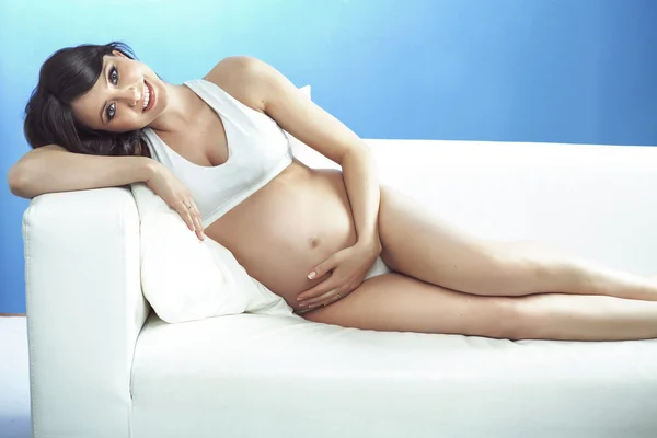 Беременная женщина лежит на диване. — стоковое фото