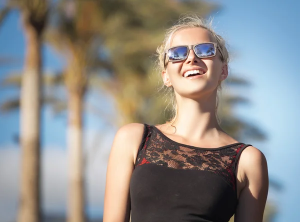 Lächelnde Frau mit trendiger Sonnenbrille im Urlaub — Stockfoto