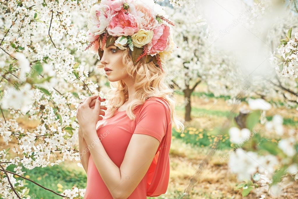 Charming blond woman walking in the orchard