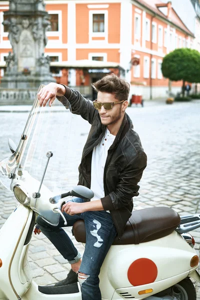 Handsome man sitting on a scooter — Stock Photo, Image