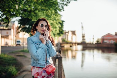 Güzel yaşlı kadın nehir kenarında poz veriyor..