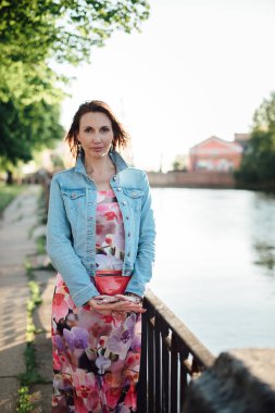 Güzel yaşlı kadın nehir kenarında poz veriyor..