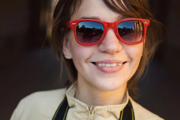 Kırmızı güneş gözlüğü gülümseyen kız