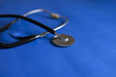 Mavi arka planda steteskopun bir parçası. Seçici odak, uzayı kopyala. Kardiyoloji kavramı