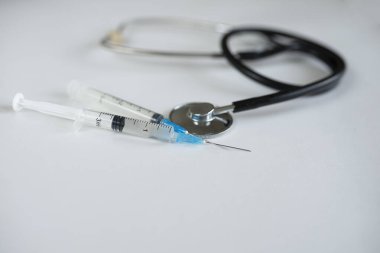 Şırınga ve termometre, beyaz arka planda steteskop. Yakın plan. seçici odaklanma, kopyalama alanı. Yukarıdan bak. Kardiyoloji kavramı