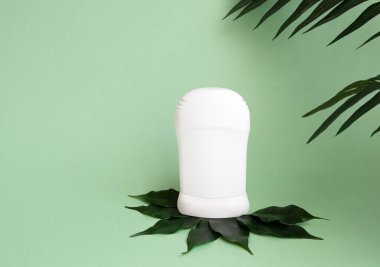 Cilt bakımı kozmetik şişesi, deodorant, çay ağacı yapraklı doğal kozmetik ürünleri ve mavi arka planda tropikal yapraklar. Boşluğu kopyala