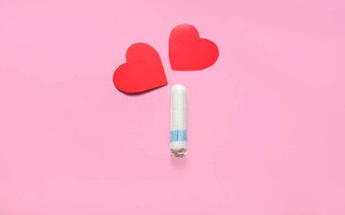 Pembe arka planda kırmızı kalplerin uygulaması ve tamponu. Kadın regl konsepti. kopyalama alanı. en üstteki görünüm